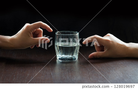 An optimist and a pessimist's opinion about a glass of water An optimist and a pessimist's opinion about a glass of water 128019697