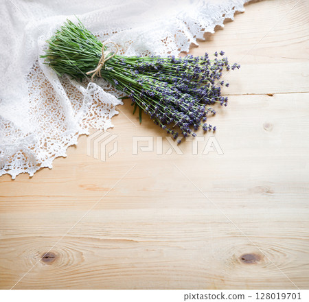 Lavender flowers lie on the table on lace 128019701
