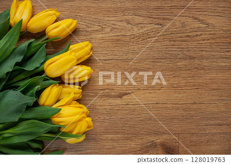 yellow tulips on wooden background yellow tulips on wooden background 128019763