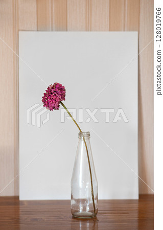 Colorful Dried Flowers Arranged in a Glass Vase on a Wooden Surface 128019766