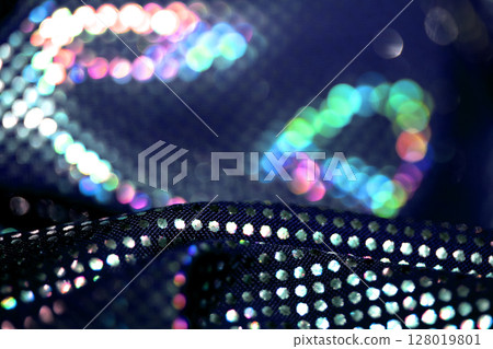 Holographic shiny spots and dots bokeh on fabric for a futuristic disco background 128019801