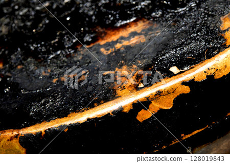 Close up of heavy black rust on a brass base of a kitchen sauce pan abstract background Close up of heavy black rust on a brass base of a kitchen sauce pan abstract background 128019843