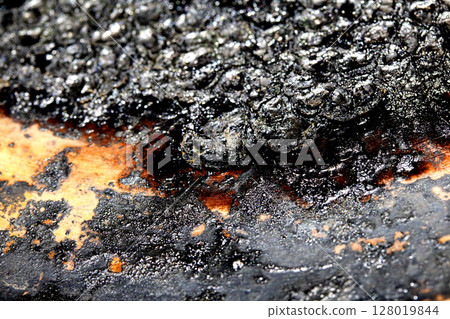 Close up of heavy black rust on a brass base of a kitchen sauce pan abstract background Close up of heavy black rust on a brass base of a kitchen sauce pan abstract background 128019844