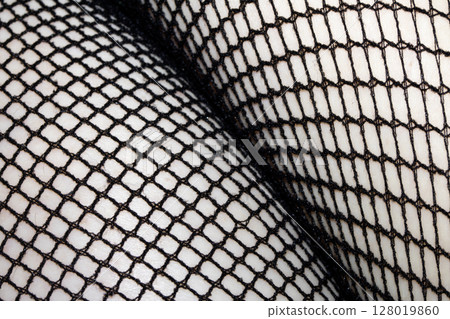 Close up of black fishnet tights on skin legs curves abstract background Close up of black fishnet tights on skin legs curves abstract background 128019860