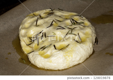 Close up of home made focaccia bread dough ready to be baked in the oven with rosemary 128019878