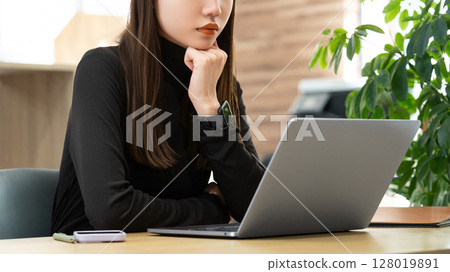 Woman/businesswoman thinking while using a computer 128019891