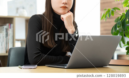 Woman/businesswoman thinking while using a computer Woman/businesswoman thinking while using a computer 128019893