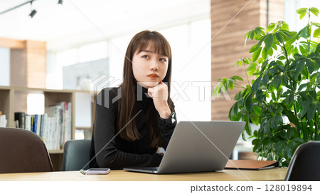 Woman/businesswoman thinking while using a computer 128019894