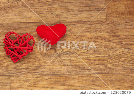 Two Red Heart-Shaped Decorations on Rustic Wooden Surface 128020079