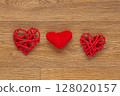 Two Red Heart-Shaped Decorations on Rustic Wooden Surface 128020157