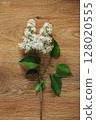 White Lilac Flower on Wooden Surface with Green Leaves Arrangement 128020555