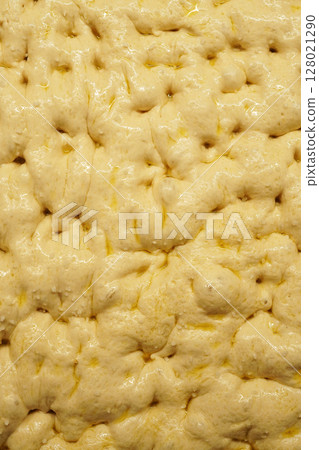 Close-up of risen focaccia dough before baking in the oven Close-up of risen focaccia dough before baking in the oven 128021290