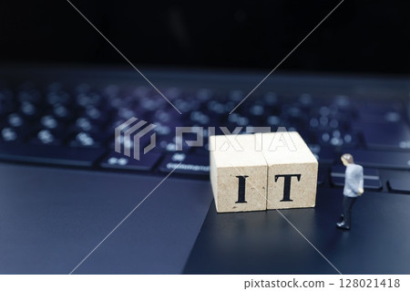 A miniature model of a businessman looking at IT A miniature model of a businessman looking at IT 128021418