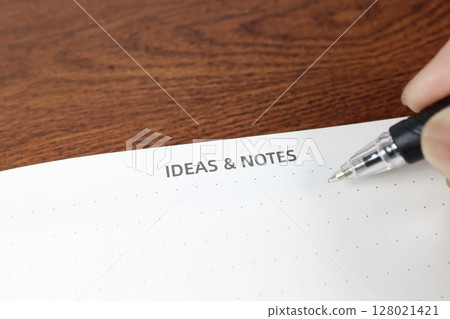 Notepad and ballpoint pen with copy space on wood grain table Notepad and ballpoint pen with copy space on wood grain table 128021421