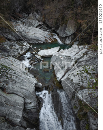 Pristine water flowing between weathered rocks, revealing untamed natural beauty of mountainous aosta valley landscape in italy pontboset Pristine water flowing between weathered rocks, revealing untamed natural beauty of mountainous aosta valley landscape in italy pontboset 128021980