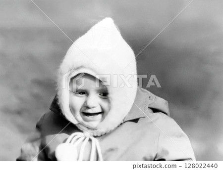 Vintage portrait of a cute little boy in a white cap walking on the street in spring. Retro photo from 1967. 128022440
