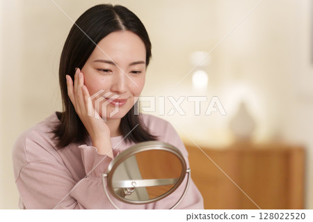 Woman doing skin care at night Woman doing skin care at night 128022520