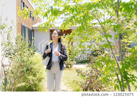 一位穿著西裝的女士走出家門 一位穿著西裝的女士走出家門 128025075