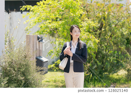 一位穿著西裝的女士走出家門 128025140