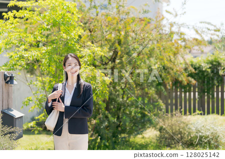 一位穿著西裝的女士走出家門 128025142