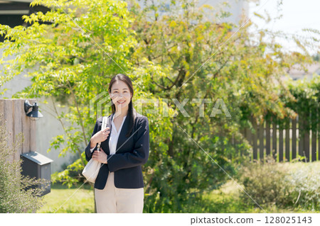 一位穿著西裝的女士走出家門 128025143