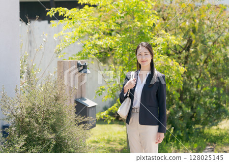 一位穿著西裝的女士走出家門 128025145