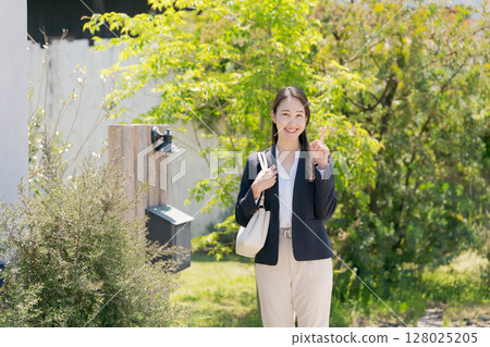 一位穿著西裝的女士走出家門 128025205