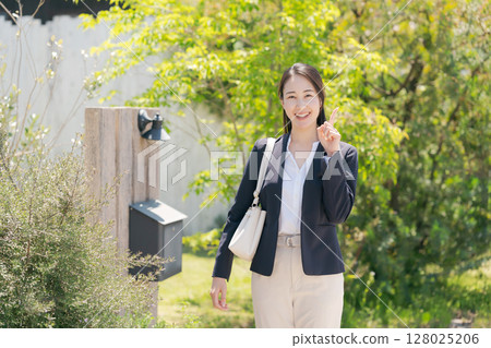 一位穿著西裝的女士走出家門 128025206