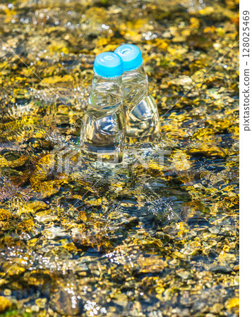 Two bottles of Ramune cooled with cold river water in summer 128025469