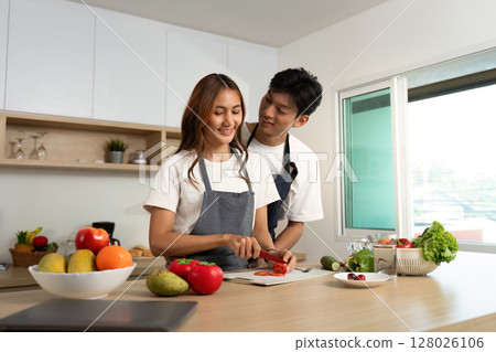 Couple Cooking Together. Smiling While Preparing Fresh Ingredients. 128026106