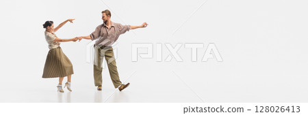 Retro dance couple performing lively swing in vintage attire against plain white background. Banner Retro dance couple performing lively swing in vintage attire against plain white background. Banner 128026413