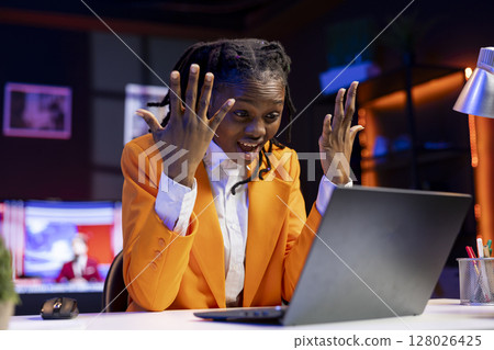 Angry freelancer at desk yelling while working from home in apartment office, upset by error on laptop screen. Stressed woman raging, having burnout while doing tasks on notebook 128026425