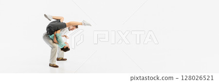 Energetic dancers performing acrobatic retro dance move against plain white background. Banner Energetic dancers performing acrobatic retro dance move against plain white background. Banner 128026521