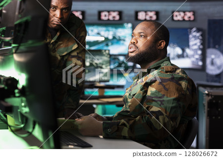 Military professional reporting battlefield information to army decision maker in headquarters. African american dispatcher talking with general, showing enemy coordinates Military professional reporting battlefield information to army decision maker in headquarters. African american dispatcher talking with general, showing enemy coordinates 128026672