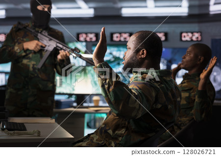 Dangerous terrorist threatening soldiers with rifles after hijacking their base of operations. Outlaw using gun to control kidnapped hostages during guerilla warfare armed conflict Dangerous terrorist threatening soldiers with rifles after hijacking their base of operations. Outlaw using gun to control kidnapped hostages during guerilla warfare armed conflict 128026721