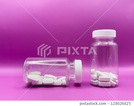 An bottle of white pills. Pills on a pink background. pills studio isolated over white. 128026825