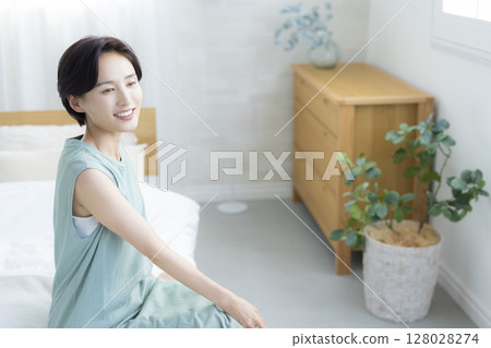 A woman sitting on a bed A woman sitting on a bed 128028274