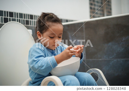 toddler girl washing nasal with syringe and saline by herself. cleaning nose 128028348