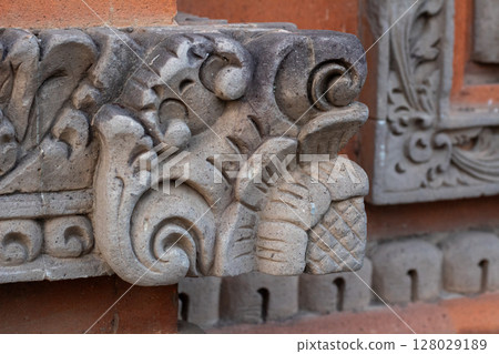 Intricate traditional stone carving detail on weathered architectural building facade Intricate traditional stone carving detail on weathered architectural building facade 128029189