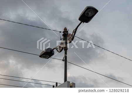 Decorative vintage street lamp with double lights against a cloudy sky. 128029218