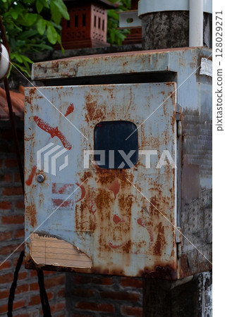 Close-up view of heavily rusted and weathered metal electrical box outdoors Close-up view of heavily rusted and weathered metal electrical box outdoors 128029271