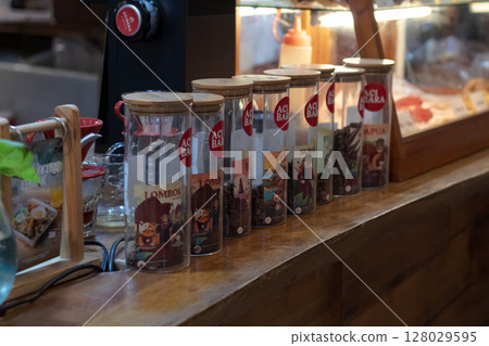 Row of glass jars filled with different origin roasted coffee beans on a wooden shelf. at Mataram, Indonesia on November 10, 2024 Row of glass jars filled with different origin roasted coffee beans on a wooden shelf. at Mataram, Indonesia on November 10, 2024 128029595