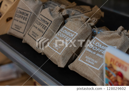 Close up of small burlap bags filled with organic Lombok coffee beans at Mataram, Indonesia on November 10, 2024 128029602