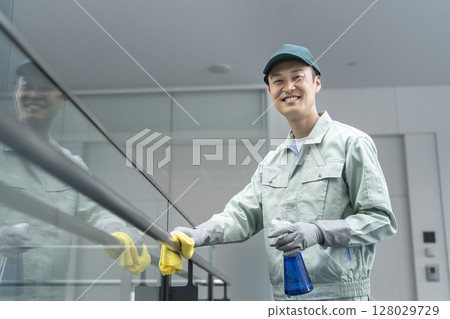 微笑的男清潔人員看著相機建築清潔影像 128029729