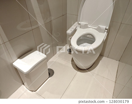 Modern bathroom interior with clean toilet and waste bin 128030179