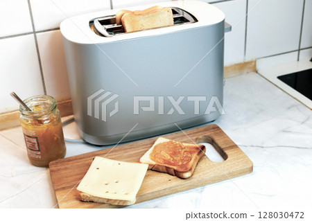 Breakfast served on the kitchen table with fresh toast bread and jam. Breakfast served on the kitchen table with fresh toast bread and jam. 128030472