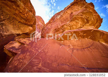 Ancient Petroglyphs on Red Sandstone Cliffs in Valley of Fire Low Angle View Ancient Petroglyphs on Red Sandstone Cliffs in Valley of Fire Low Angle View 128031052