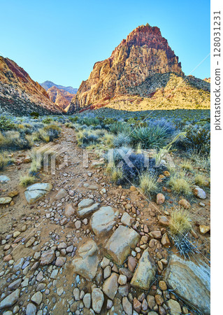 Red Rock Canyon Desert Trail with Towering Mountain in Sunlit Vista 128031231