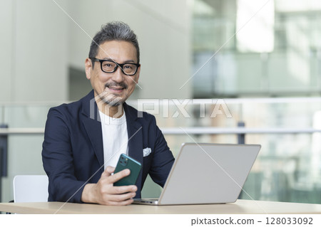 Senior businessman with a smartphone Senior businessman with a smartphone 128033092