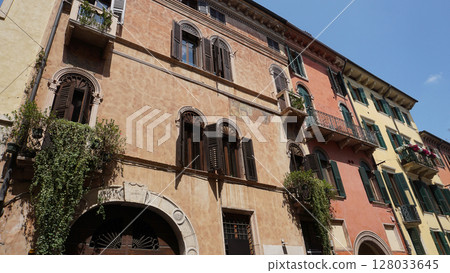 Beautiful traditional Italian building with flowers on balcony of medieval wall, Verona, Italy Beautiful traditional Italian building with flowers on balcony of medieval wall, Verona, Italy 128033645